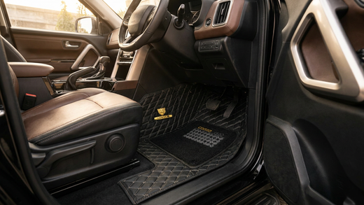 A premium black 7D leatherette floor mat installed in a car footwell