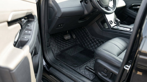 A pristine black 7D moulded floor mat installed in a modern car footwell