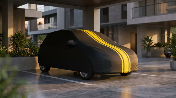 Silver hatchback in an Indian parking spot under a snug black DriveCult body cover with yellow stripes