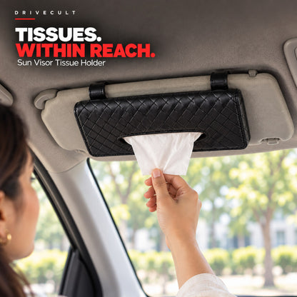Sun visor tissue holder clipped to a car sun visor, a hand pulling out a tissue